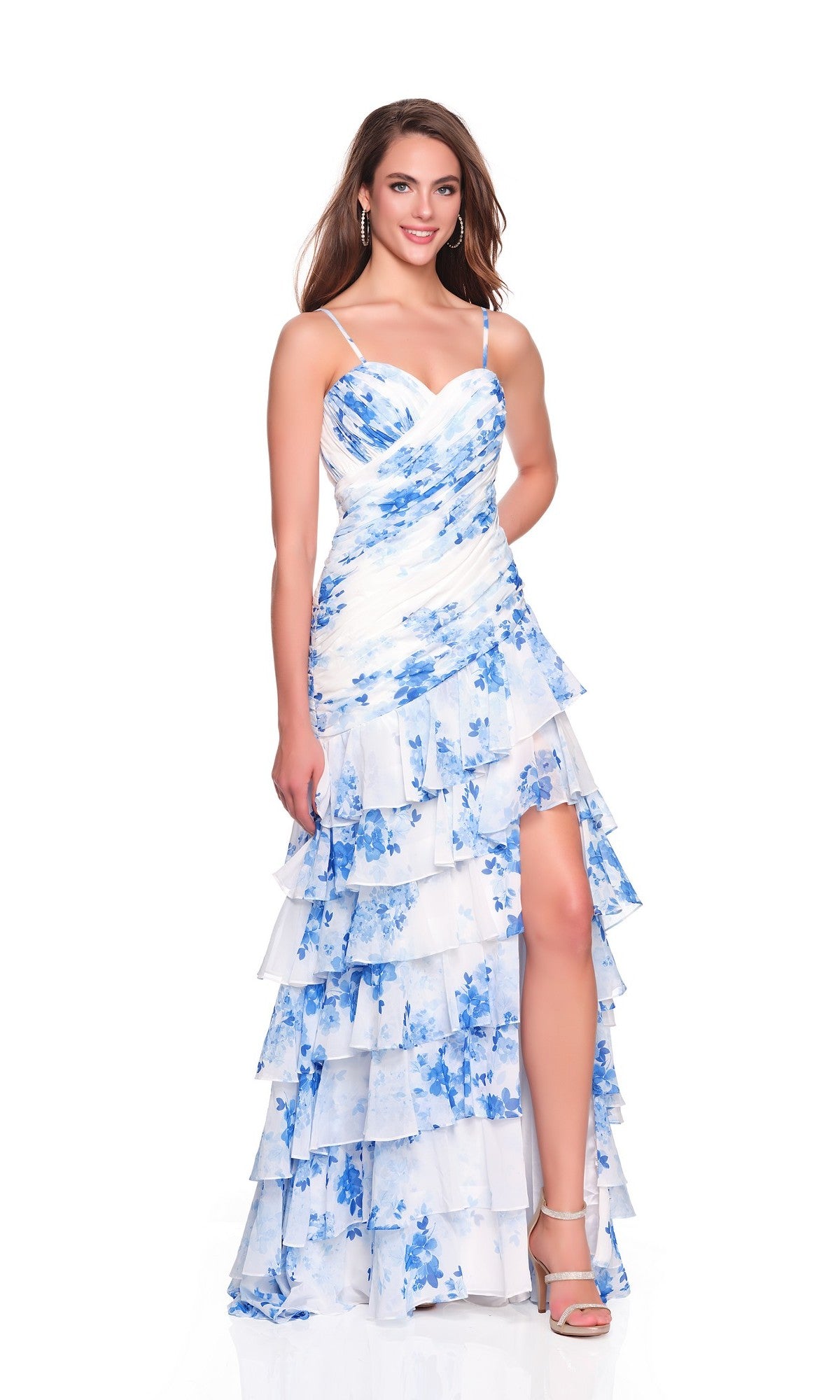 A woman models the Dave and Johnny 12939 long prom dress—a white and blue chiffon gown with tiered ruffles, sweetheart neckline, and thigh-high slit—posing against a white background.